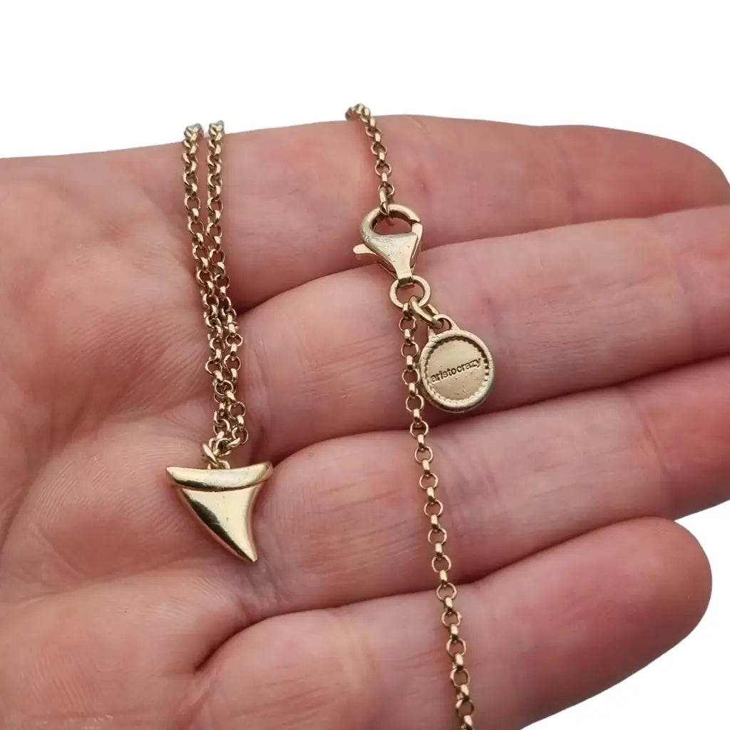 Collar de cadena en plata dorada y colgante colmillo también dorada.