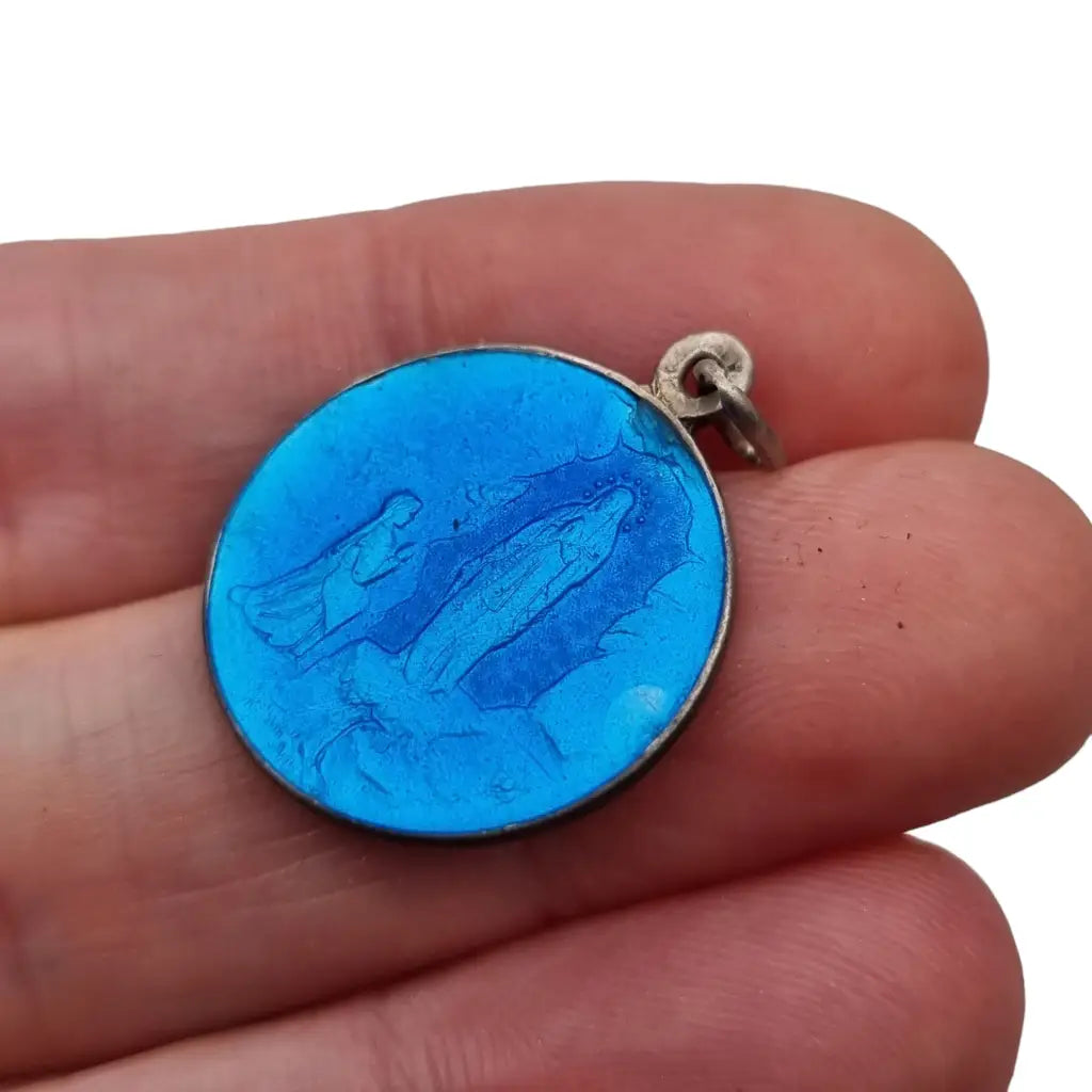 Colgante religioso de virgen maría en plata y esmalte azul.