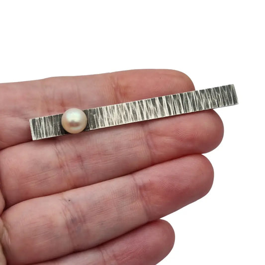 Broche moderno en plata martillada con perla cultivada diseño minimalista