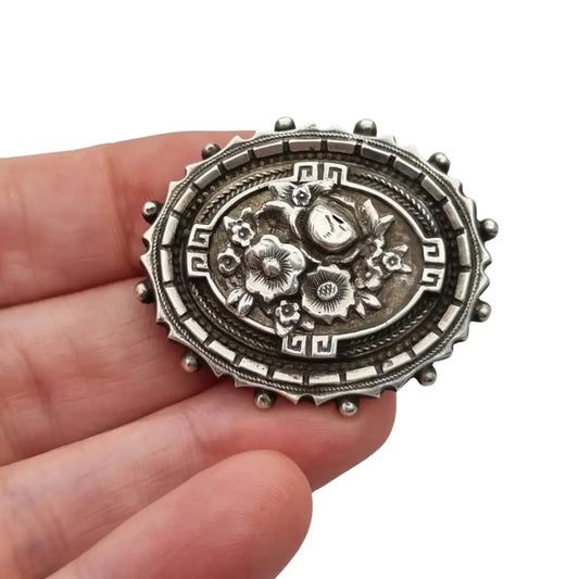 Broche relicario victoriano en plata de ley con flores relieve. Circa 1910.