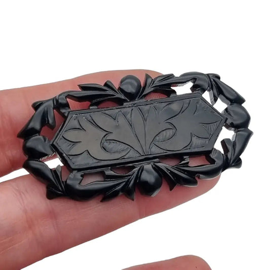 Broche vintage de baquelita negra tallas geométricas para la solapa.