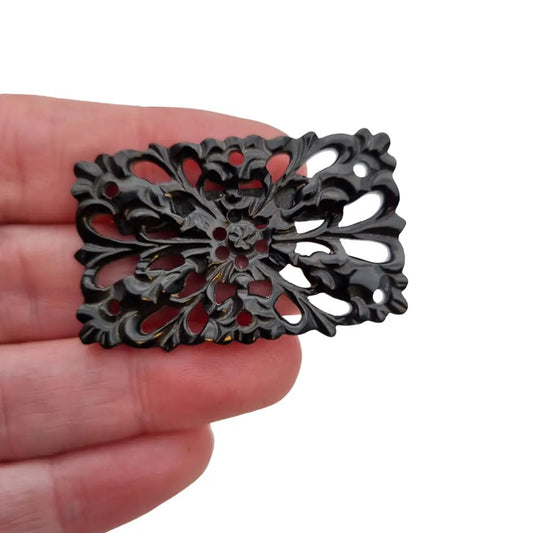 Broche vintage de baquelita tallada negra motivos florales para la solapa