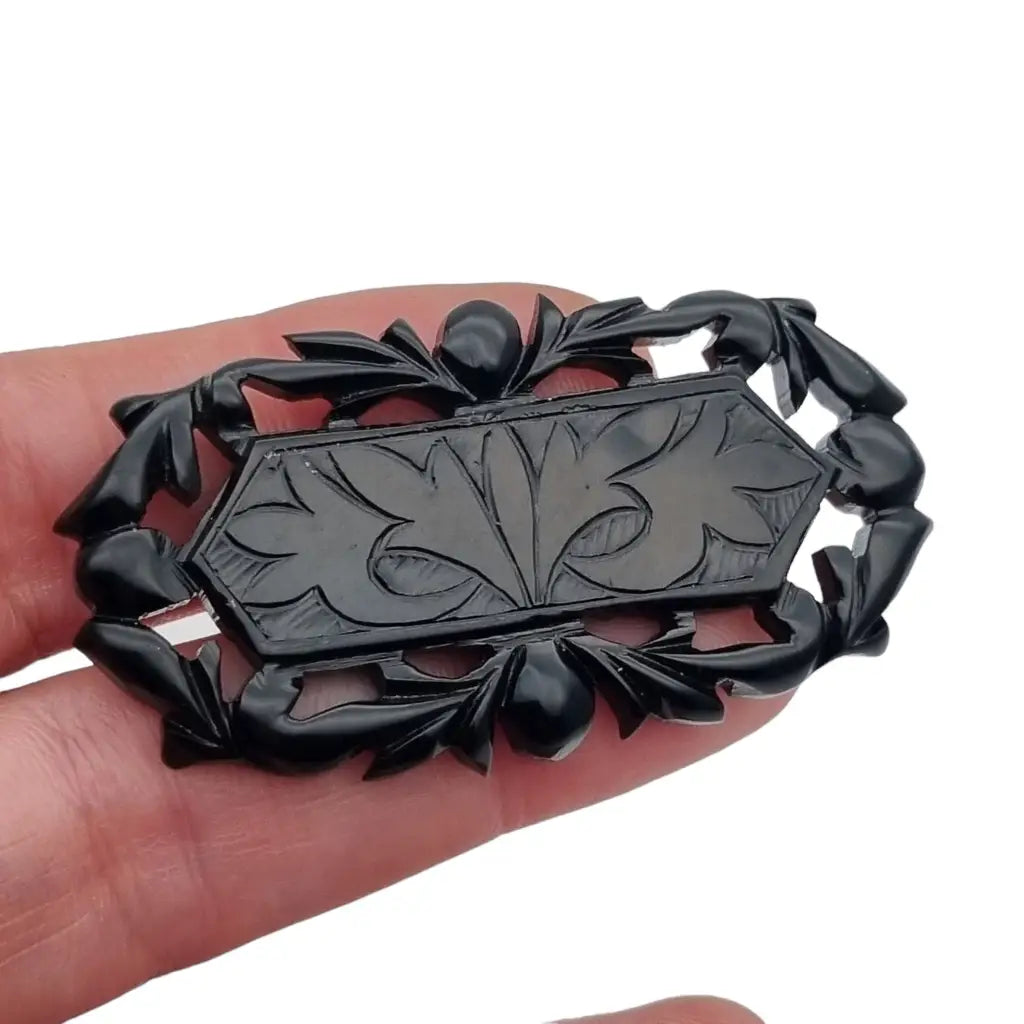 Broche vintage de baquelita negra tallas geométricas para la solapa.