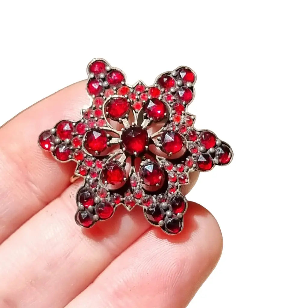 Broche de granates victoriano antiguo en plata dorada flor copo nieve.