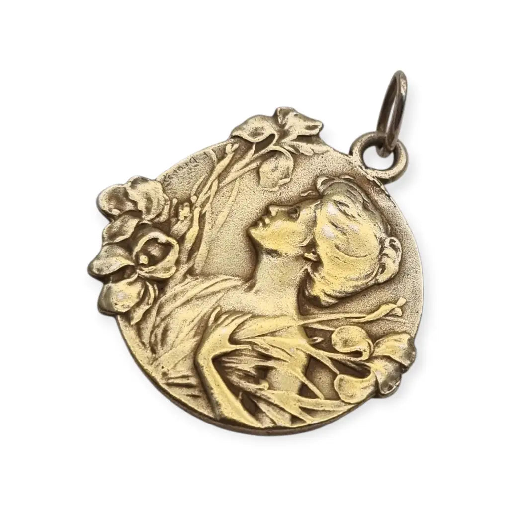 Medalla colgante Art Nouveau en plata dorada con mujer entre lirios firmada E.