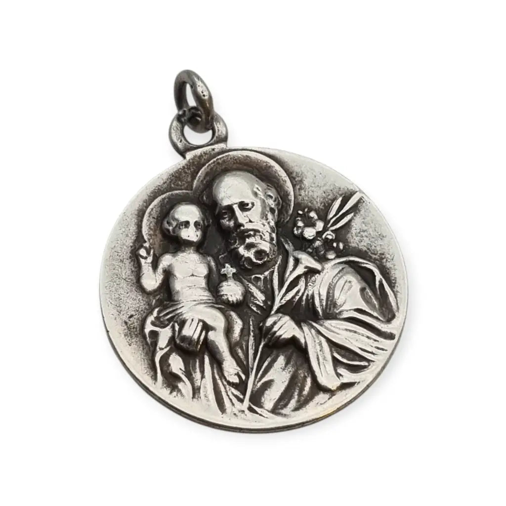 Medalla religiosa antigua en plata maciza de San José y el Niño fechada 1920.