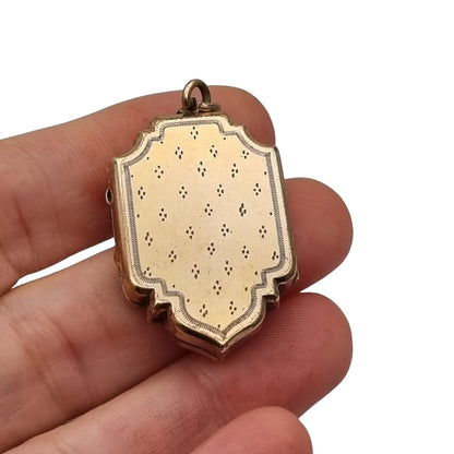 Victorian locket in gilt metal, engraved in the shape of a shield, circa 1900