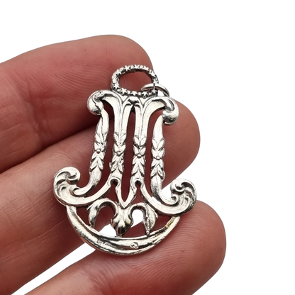 Colgante mariano monograma M en plata calada Art Nouveau, joya religiosa, circa 1900–1925
