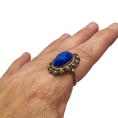 Mid-Century silver ring with blue cabochon and highly ornate floral frame, 1960