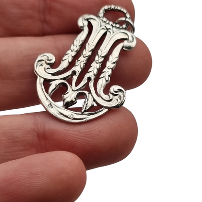 Colgante mariano monograma M en plata calada Art Nouveau, joya religiosa, circa 1900–1925