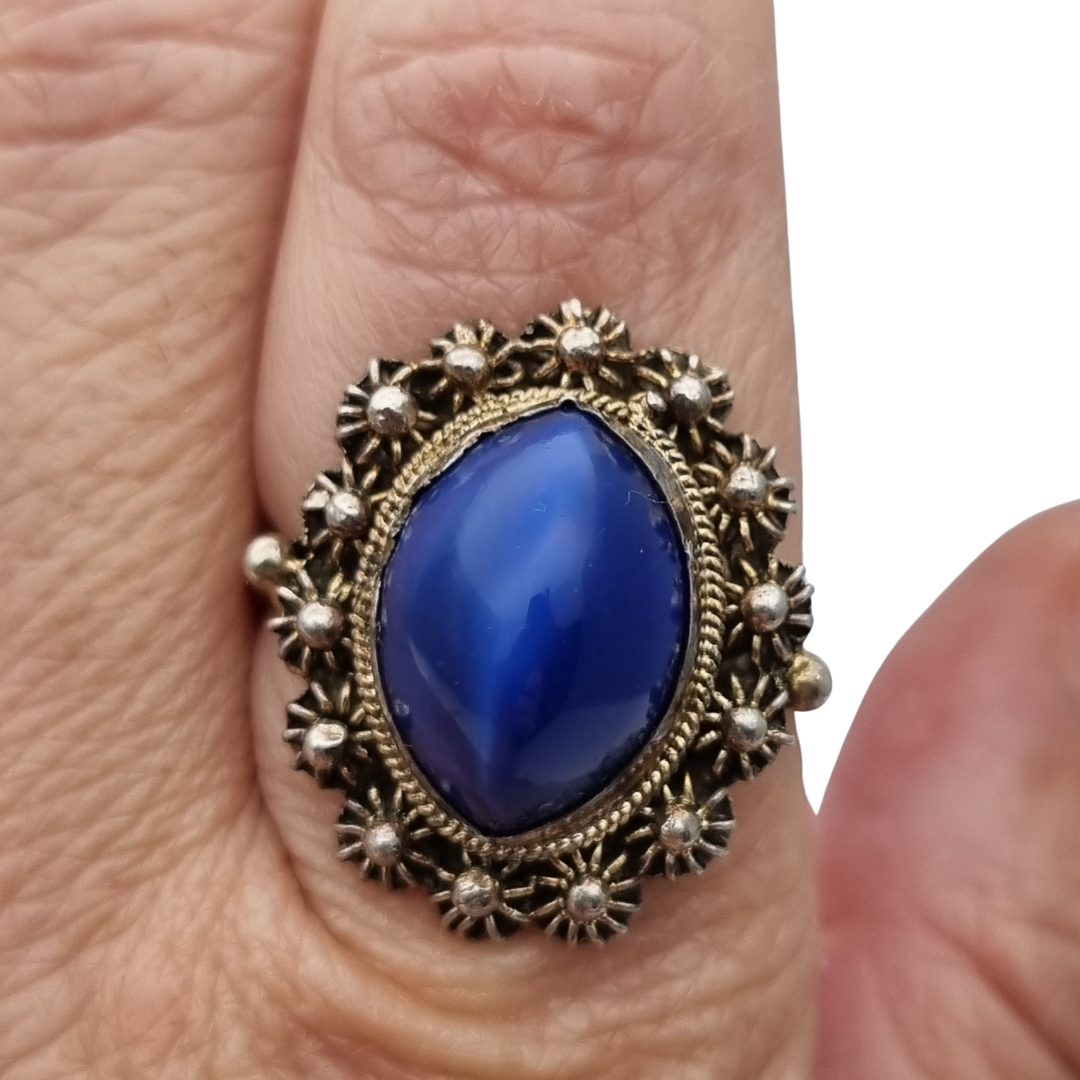 Mid-Century silver ring with blue cabochon and highly ornate floral frame, 1960