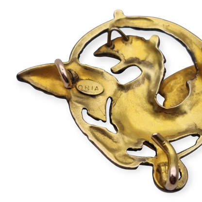 Broche Art Nouveau de grifo ORIA en oro laminado y ojo de rubí, circa 1910