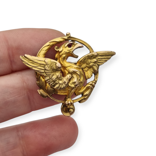 Broche Art Nouveau de grifo ORIA en oro laminado y ojo de rubí, circa 1910