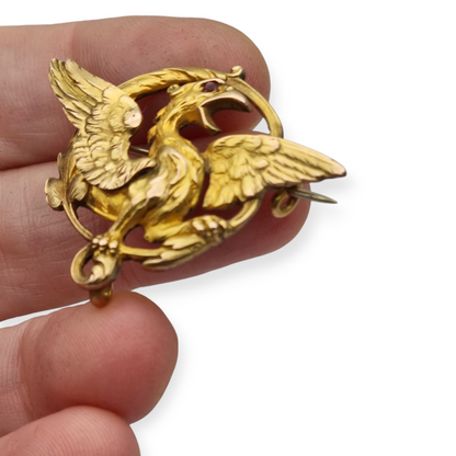 Broche Art Nouveau de grifo ORIA en oro laminado y ojo de rubí, circa 1910