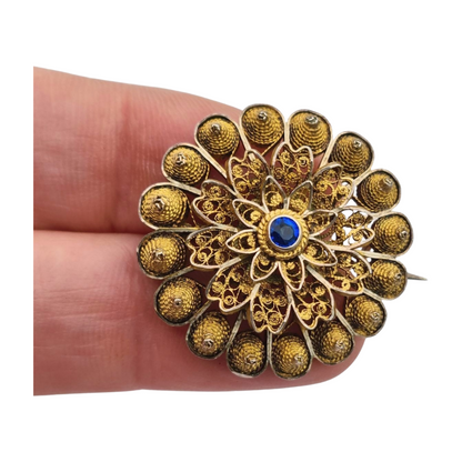 Floral brooch from the 1930s-40s in gilded silver with blue crystal and oriental filigree