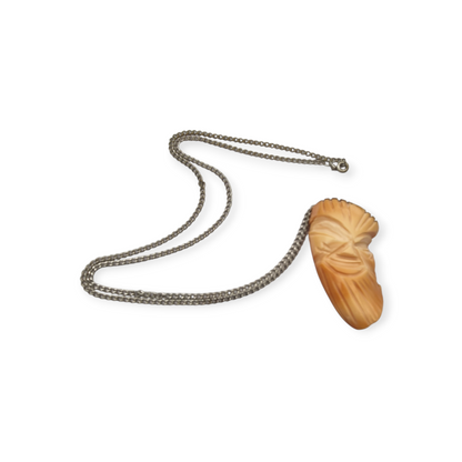 Colgante oriental con forma de máscara tallada en coral piel de ángel y plata, circa 1960-70