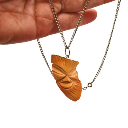 Colgante oriental con forma de máscara tallada en coral piel de ángel y plata, circa 1960-70