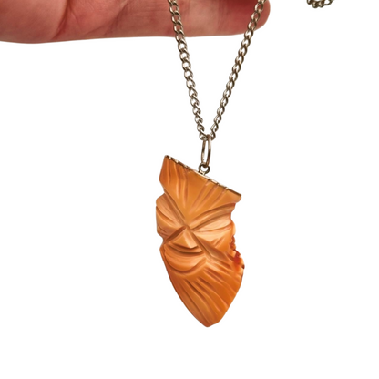 Colgante oriental con forma de máscara tallada en coral piel de ángel y plata, circa 1960-70