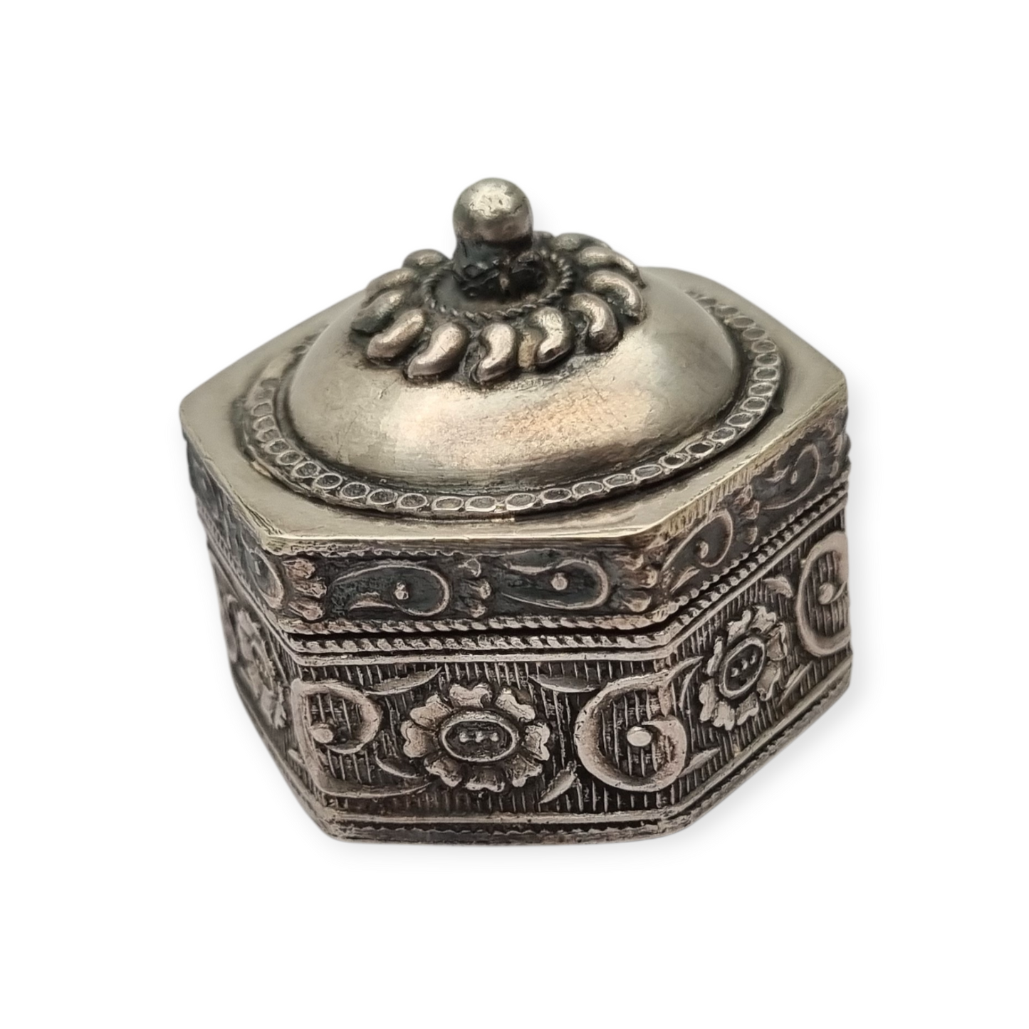 Hexagonal oriental ethnic silver box with floral relief and domed lid, circa 1970
