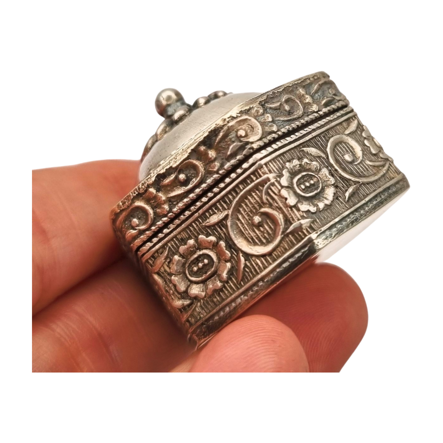 Hexagonal oriental ethnic silver box with floral relief and domed lid, circa 1970