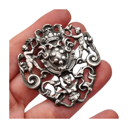 Neo-Renaissance silver brooch, heraldic shield with cherubs Italy 20th century