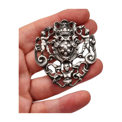 Neo-Renaissance silver brooch, heraldic shield with cherubs Italy 20th century