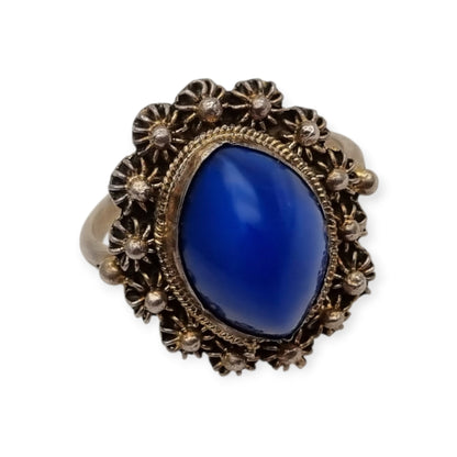 Mid-Century silver ring with blue cabochon and highly ornate floral frame, 1960