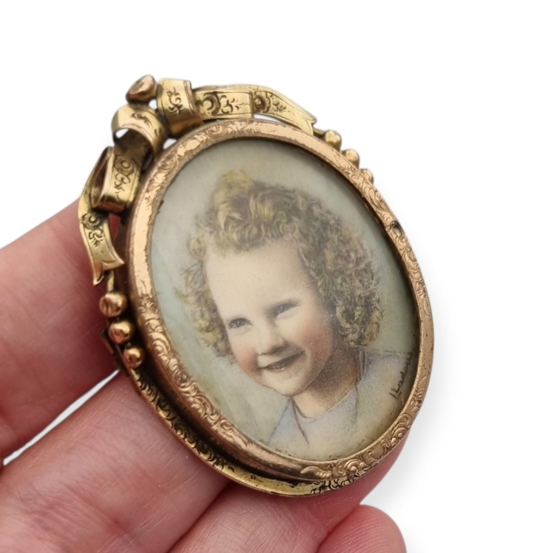Belle Époque gilded metal locket brooch with Louis XV style miniature child portrait, circa 1890-1910