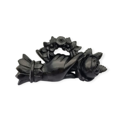 Broche victoriano de mano con rosa y corona floral, probable vulcanita, joyería sentimental circa 1870–1890