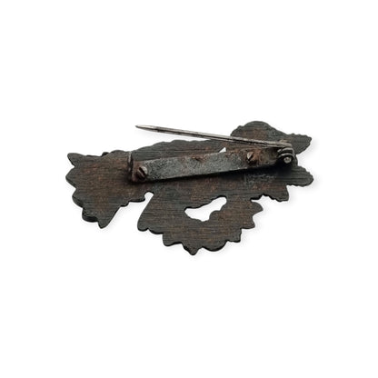Broche victoriano de mano con rosa y corona floral, probable vulcanita, joyería sentimental circa 1870–1890