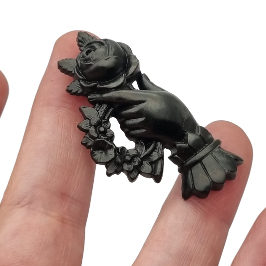 Victorian hand brooch with rose and floral wreath, likely vulcanite, sentimental jewelry circa 1870–1890