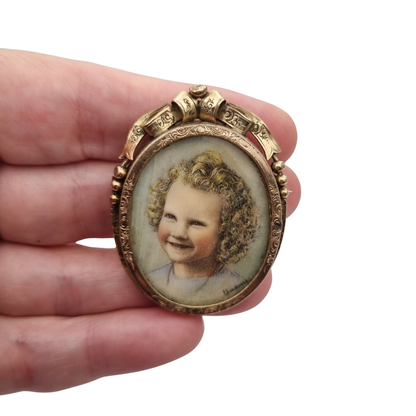 Belle Époque gilded metal locket brooch with Louis XV style miniature child portrait, circa 1890-1910