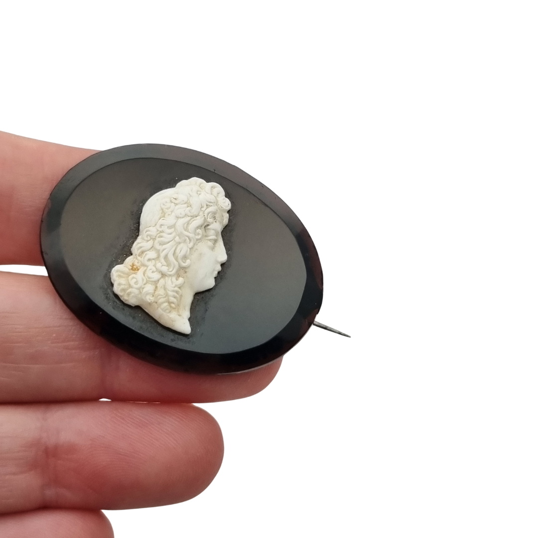 Broche vintage con camafeo neoclásico aplicado, placa negra oval y perfil clásico, circa 1930–1960