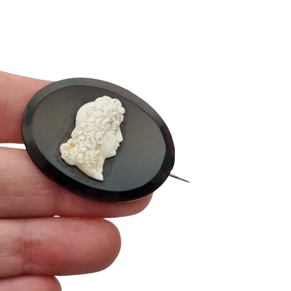 Broche vintage con camafeo neoclásico aplicado, placa negra oval y perfil clásico, circa 1930–1960