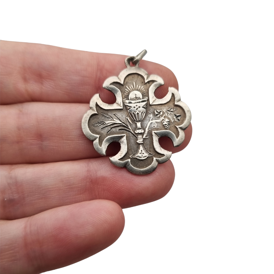 Medalla religiosa antigua de Primera Comunión en plata con cáliz, espigas e inscripción de 1895