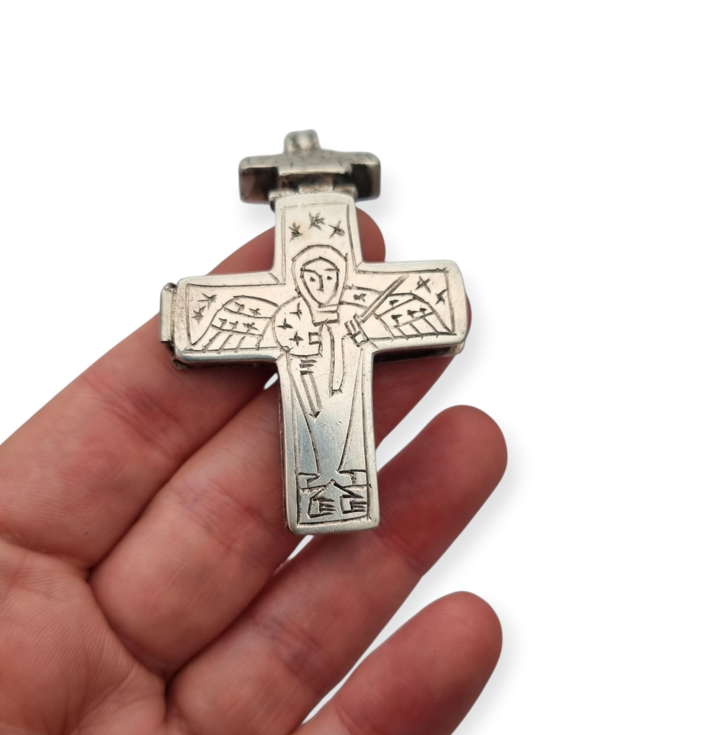 Antique Byzantine-style silver reliquary cross with engraved religious scenes.