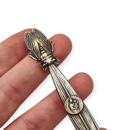 Abrecartas vintage con cigarra en relieve y medalla religiosa de Notre-Dame