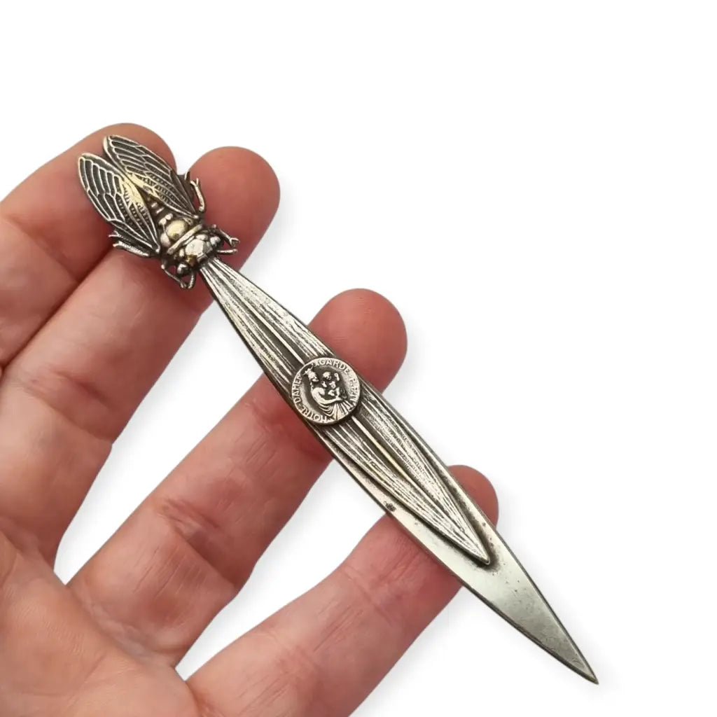 Abrecartas vintage con cigarra en relieve y medalla religiosa de Notre-Dame