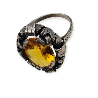 Anillo antiguo Art Deco en plata con cristal amarillo ovalado y diseño floral.