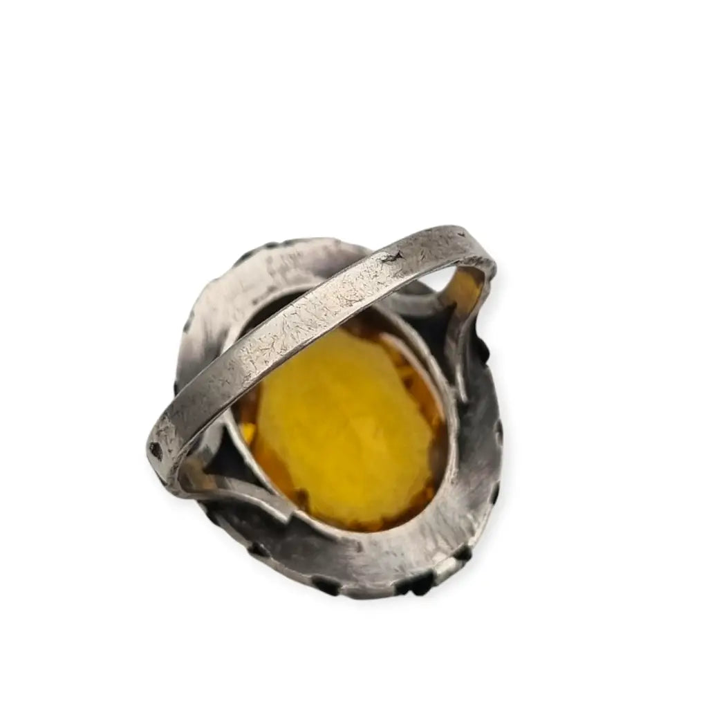 Anillo antiguo Art Deco en plata con cristal amarillo ovalado y diseño floral.