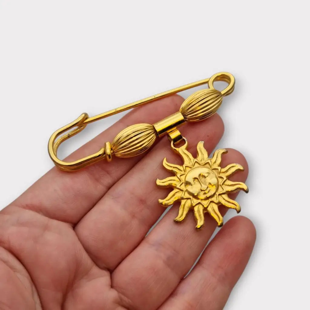 Broche y alfiler de seguridad vintage bañado en oro con colgante cara sol