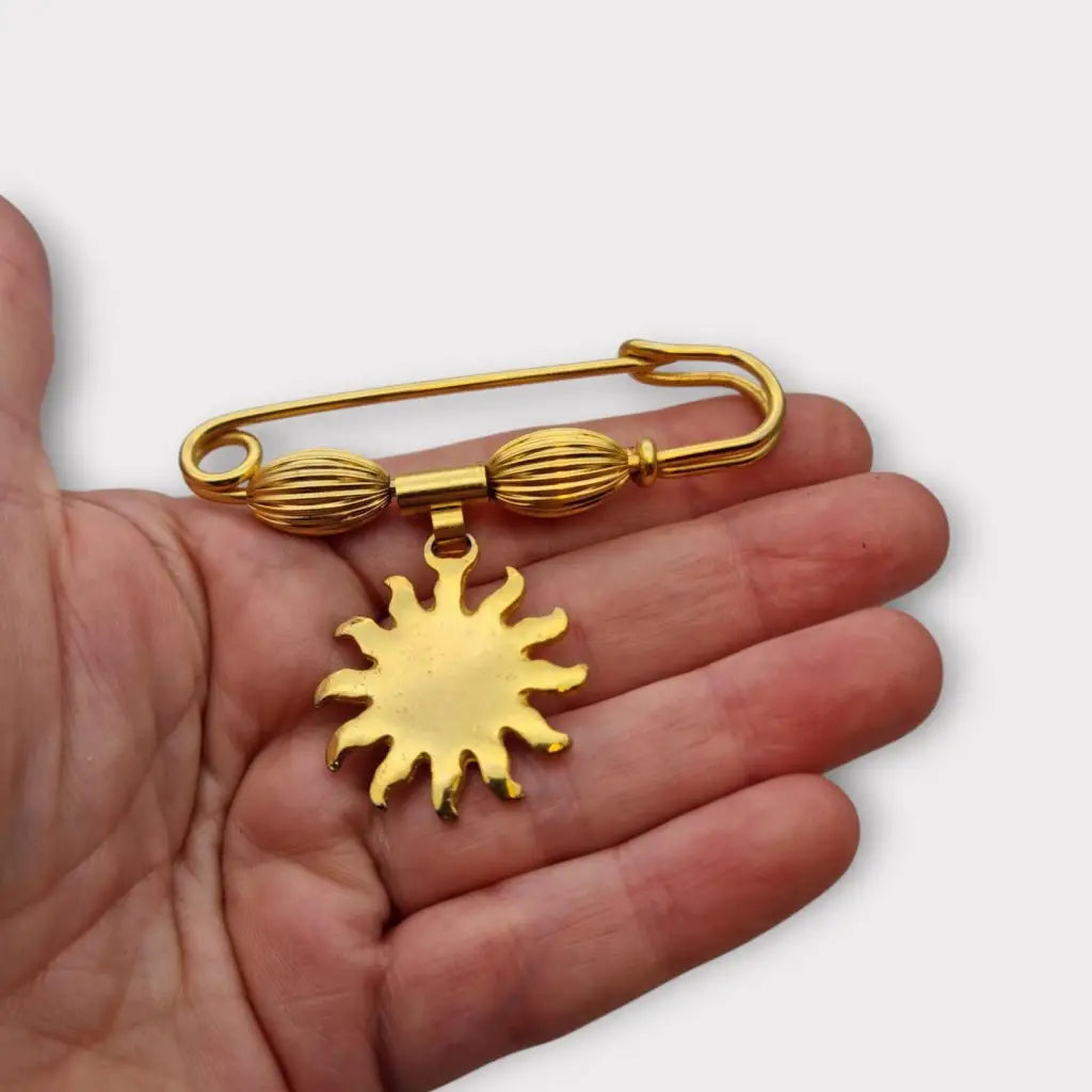 Broche y alfiler de seguridad vintage bañado en oro con colgante cara sol