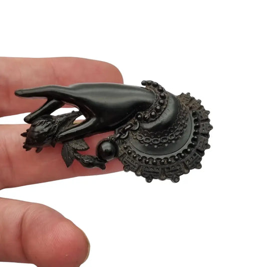 Broche antiguo victoriano en forma de mano sosteniendo flor vulcanita joya