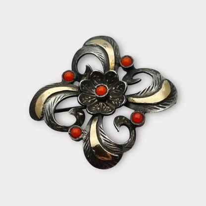 Broche Art Decó en plata con piedra roja y diseño floral detalles dorados