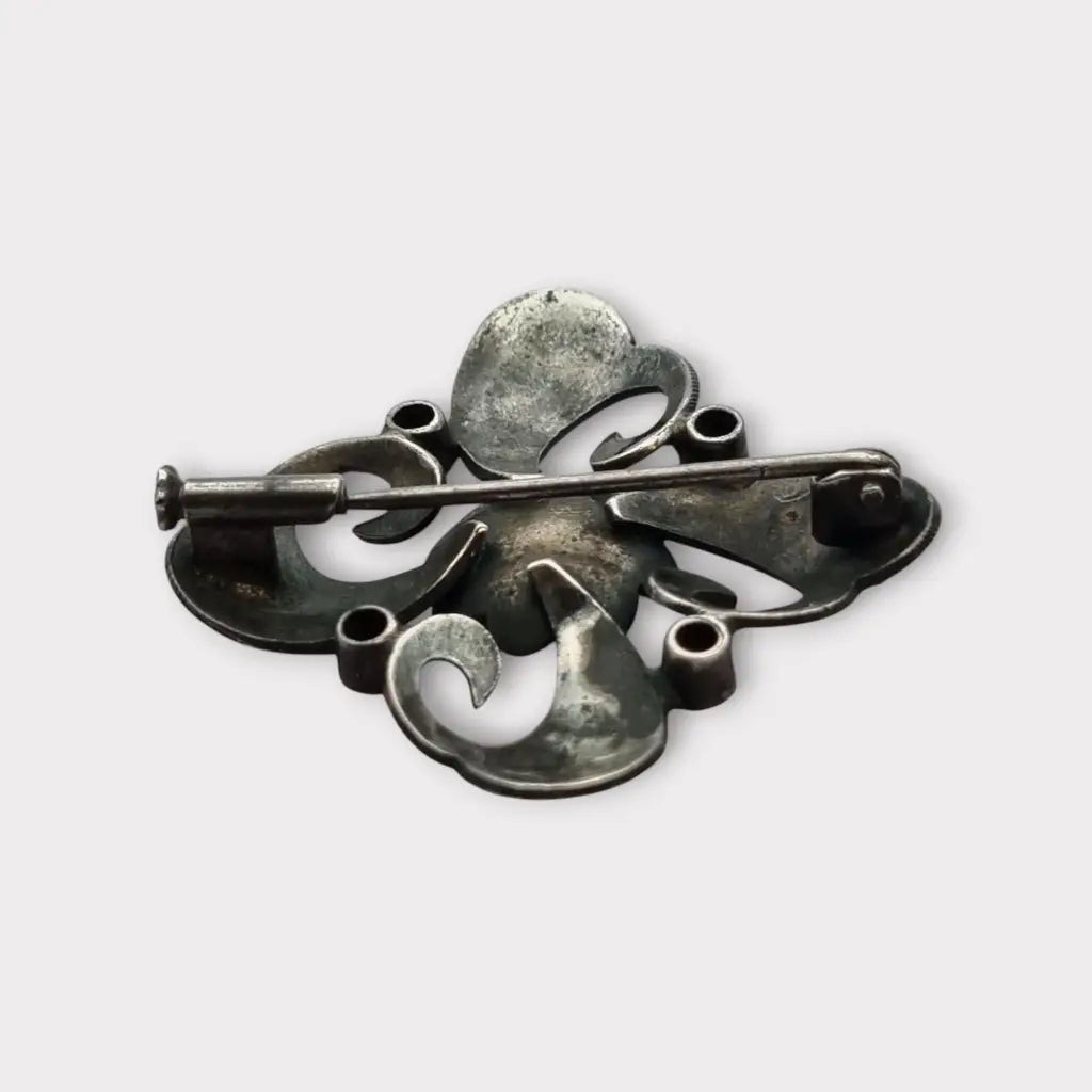 Broche Art Decó en plata con piedra roja y diseño floral detalles dorados
