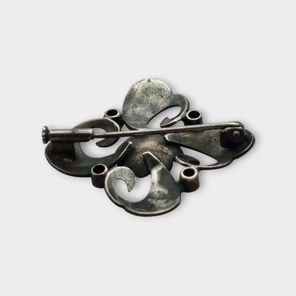 Broche Art Decó en plata con piedra roja y diseño floral detalles dorados
