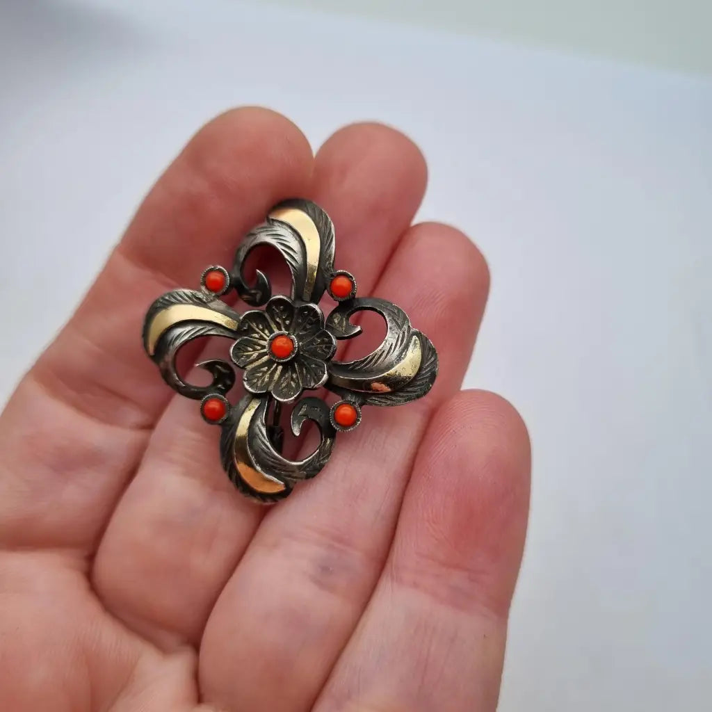 Broche Art Decó en plata con piedra roja y diseño floral detalles dorados
