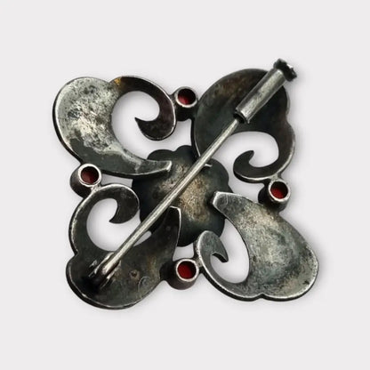Broche Art Decó en plata con piedra roja y diseño floral detalles dorados