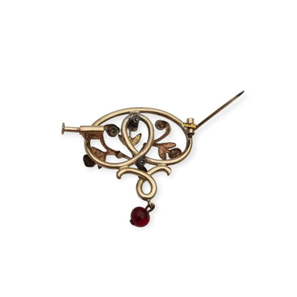 Broche Art Nouveau dorado con flor calada perlas y granates Circa 1900.