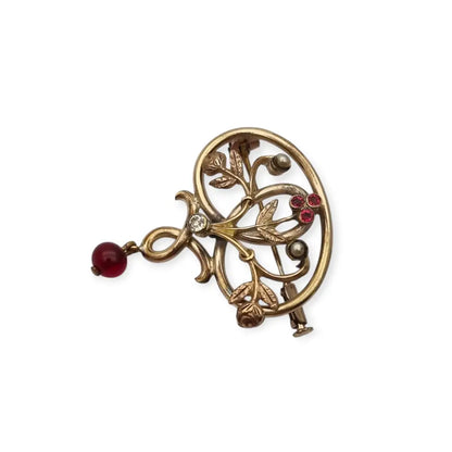 Broche Art Nouveau dorado con flor calada perlas y granates Circa 1900.